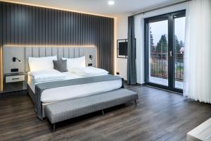 a bedroom with a large bed and a balcony at PARKHOTEL BRAUNAU - 24 Stunden Self Check-IN in Braunau am Inn