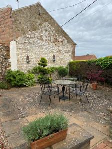 a patio with a table and chairs in front of a building at Curlew Cottage in Sedgeford