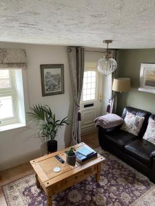 a living room with a couch and a coffee table at Curlew Cottage in Sedgeford