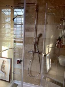 La salle de bains est pourvue d'une douche avec une porte en verre. dans l'établissement Purple House, à Saint-Valery-sur-Somme