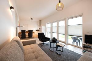ein Wohnzimmer mit einem Sofa und einem TV in der Unterkunft 95, gelegen aan het natuurmonument de Kampina in Oisterwijk