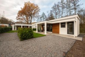 ein Haus mit vielen Fenstern in der Unterkunft 95, gelegen aan het natuurmonument de Kampina in Oisterwijk