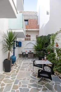 een patio met een tafel, stoelen en planten bij Studios Alsos in Naxos Chora