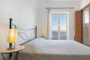 a white bedroom with a bed and a window at Casa Santi Appartamento Olivo in Giustenice