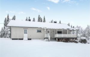 ein schneebedecktes Haus mit Bäumen im Hintergrund in der Unterkunft Awesome Home In Jordet With House A Panoramic View in Jordet