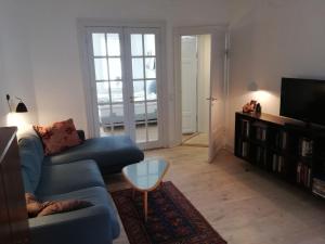 コペンハーゲンにあるApartmentInCopenhagen Apartment 397のリビングルーム(青いソファ、テレビ付)