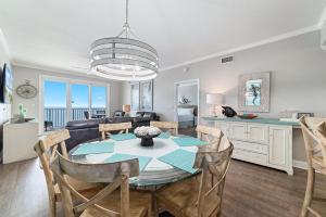 a dining room and living room with a table and chairs at Windemere 1003 in Perdido Key