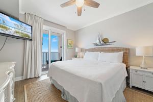 a bedroom with a bed and a flat screen tv at Windemere 1003 in Perdido Key +44 photos