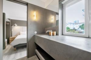 a bathroom with a tub and a bed and a window at Rainbow Suites by Olala Homes in Cascais