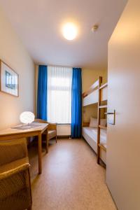 Mały pokój z biurkiem i łóżkiem piętrowym w obiekcie Michels Haus Wilhelm-Augusta w mieście Norderney
