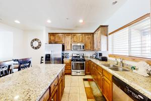 a kitchen with wooden cabinets and stainless steel appliances at Oslo Lane Ski Townhouse in Park City
