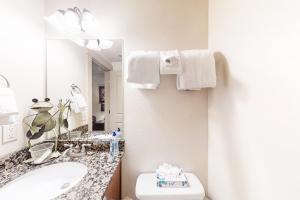 a bathroom with a sink and a toilet and a mirror at Oslo Lane Ski Townhouse in Park City +22 photos