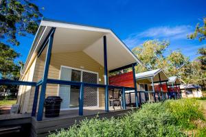 una casa con un portico perimetrale di Reflections Jimmys Beach - Holiday Park a Hawks Nest