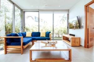 uma sala de estar com um sofá azul e uma mesa em 3 Bedroom Pool Villa 50M To The Beach em Las Terrenas
