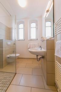 a white bathroom with a sink and a toilet at Michels Haus Wilhelm-Augusta in Norderney