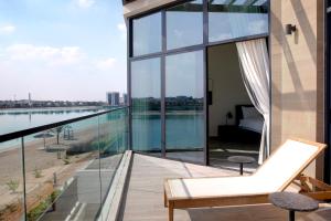 balcón con paredes de cristal y vistas al agua en Beach Villas by Olala Homes, en Ras al Khaimah