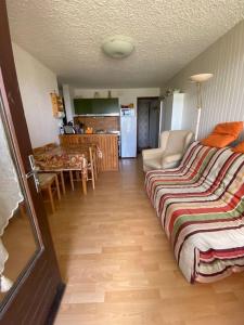 uma sala de estar com uma cama e uma cozinha em Laye Station - Appartement pieds des pistes em Laye