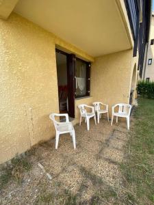 a group of white chairs sitting outside of a building at Laye Station - Appartement pieds des pistes in Laye