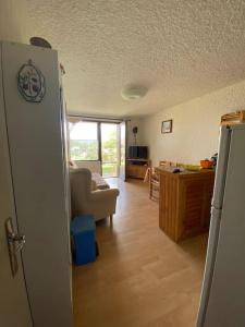 a kitchen and a living room with a refrigerator at Laye Station - Appartement pieds des pistes in Laye