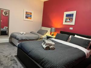 a bedroom with two beds and a red wall at The waterfront in Tarbert