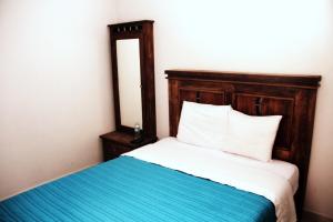 克雷塔羅的住宿－聖巴勃羅公寓式酒店，一张带木制床头板和镜子的床