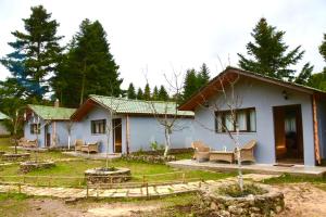 une petite maison blanche avec des chaises dans une cour dans l'établissement Νύμφες Σαλέ Αλκυόνη, 