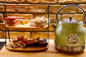 a tea kettle on a counter with a plate of food at Νύμφες Σαλέ Αλκυόνη 