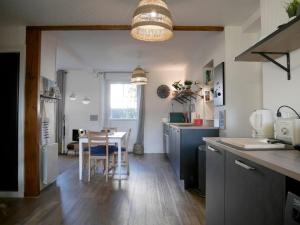 kuchnia ze stołem i jadalnią w obiekcie CLINT HOUSE - Appartement "Jardin de granit rose" w mieście Perros-Guirec
