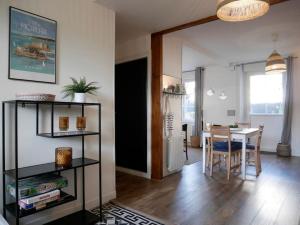 ein Wohnzimmer mit einem Tisch und einem Esszimmer in der Unterkunft CLINT HOUSE - Appartement "Jardin de granit rose" in Perros-Guirec