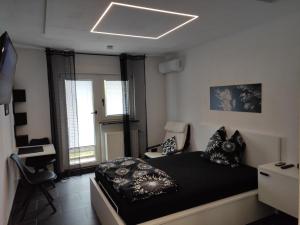 a bedroom with a black bed and a chair at Black & White Apartment in Saarbrücken