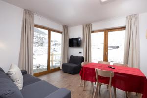 a living room with a red table and chairs at Pianeta Oro Chalet Allegra in Livigno
