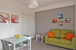sala de estar con sofá verde y mesa en Nesea Domus, en Marina di Ragusa