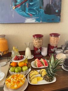 una mesa cubierta con platos de frutas y otros alimentos en Hotel Santa Catalina en Río Cuarto