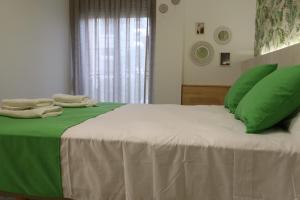 a green and white bed with green pillows on it at 203 I Posada del Mar I Encantador hostel en la playa de Gandia in Los Mártires