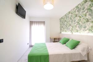 1 dormitorio con 1 cama con 2 almohadas verdes en 203 I Posada del Mar I Encantador hostel en la playa de Gandia, en Los Mártires