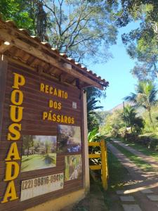 un panneau à l'entrée de l'araxido dos passas dans l'établissement Recanto dos Pássaros - Sana Chalés, à Sana