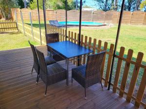 una mesa azul y sillas en una terraza con piscina en Tiny House Chaleureuse au Style Contemporain Minimaliste en Le Tampon