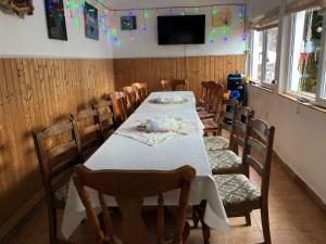 uma sala de jantar com uma mesa longa e cadeiras em Podul De Brazi - Fir Bridge em Cartisoara