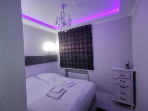 a bedroom with a bed with a pink lighting at WM Centrum Glamour z parkingiem in Białystok