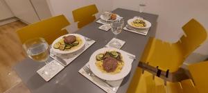 Chavasse Apartments L15DX في ليفربول: طاولة مع أطباق من الطعام وكؤوس من النبيذ