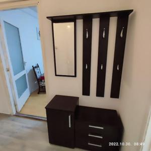 uma cómoda preta e um espelho na parede em LBB apartman em Sátoraljaújhely