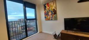 a living room with a flat screen tv and a large window at Chavasse Apartments L15DX in Liverpool