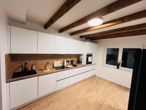 een keuken met witte kasten en een houten vloer bij Traumhaus•7Beds•CoWorking•Wifi•3ParkingSpaces in Erwitte