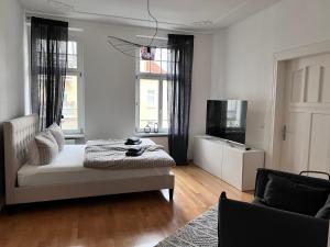 a white room with a bed and a television at Großzügiges Familien Apartment am Kressepark in Erfurt