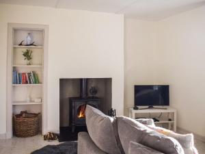 a living room with a couch and a fireplace at Ardmhor in Balquhidder