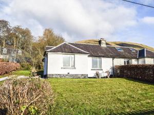 a house with a thatched roof with a yard at Ardmhor in Balquhidder