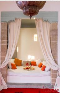 エッサウィラにあるMaison A unique chic riad in the heart of the medinaのカーテン付きの部屋のベッド1台