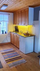 cocina con armarios de madera y encimera en Gårdshus en Lit