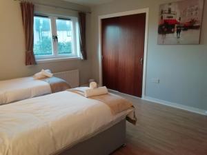 1 dormitorio con 2 camas y ventana en Carvetii - Iona House, 2nd floor apartment sleeps up to 6 en Kirkcaldy