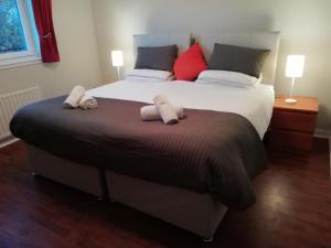 a bedroom with a large bed with two towels on it at Carvetii - Iona House, 2nd floor apartment sleeps up to 6 in Kirkcaldy